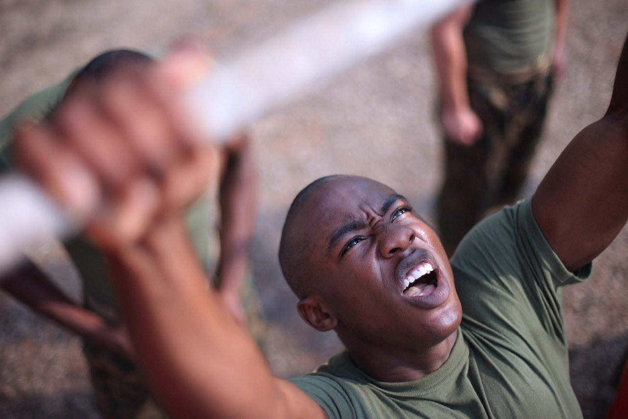 Aspiring Marine recruits doing pull ups as a group.